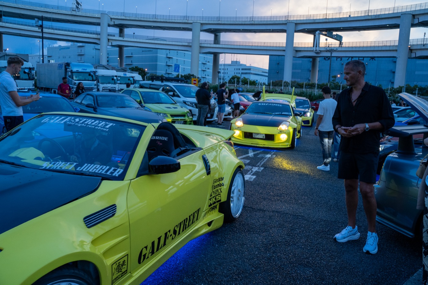 Yellow Nissan 350Z and tuned cars at a Daikoku PA gathering