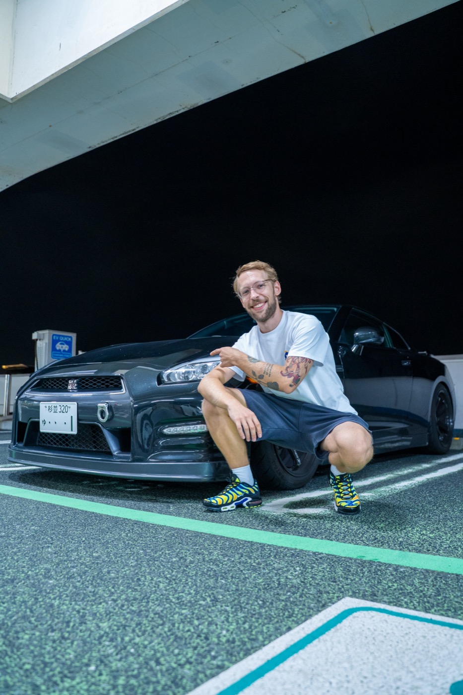 Гость рядом с чёрным Nissan GT-R R35 в Токио ночью — тур в тот же день
