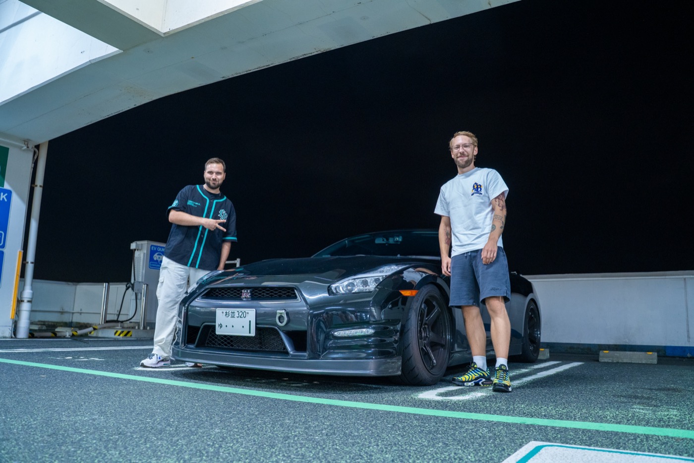 Two guests with black Nissan GTR R35 in Tokyo parking garage